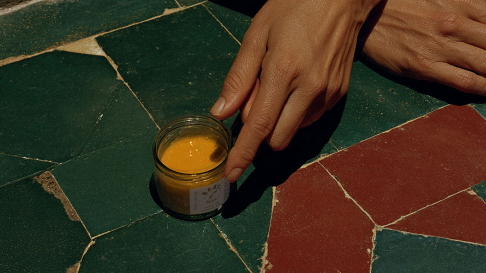 Person holding a jar of skin care balm