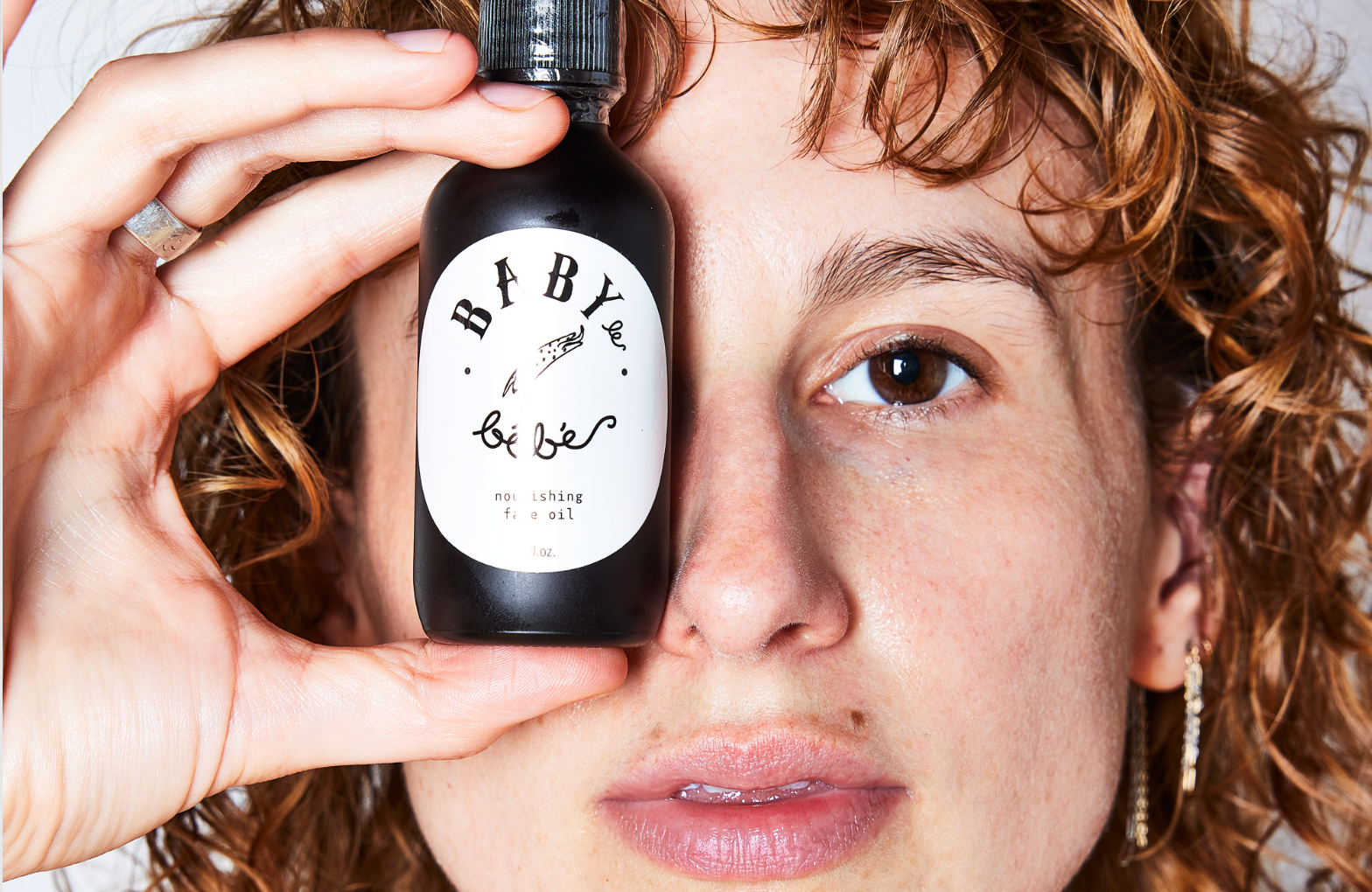 Woman holding a bottle of Nourishing Face Oil