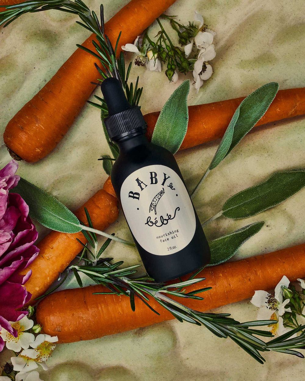 Bottle of body oil lying on carrots