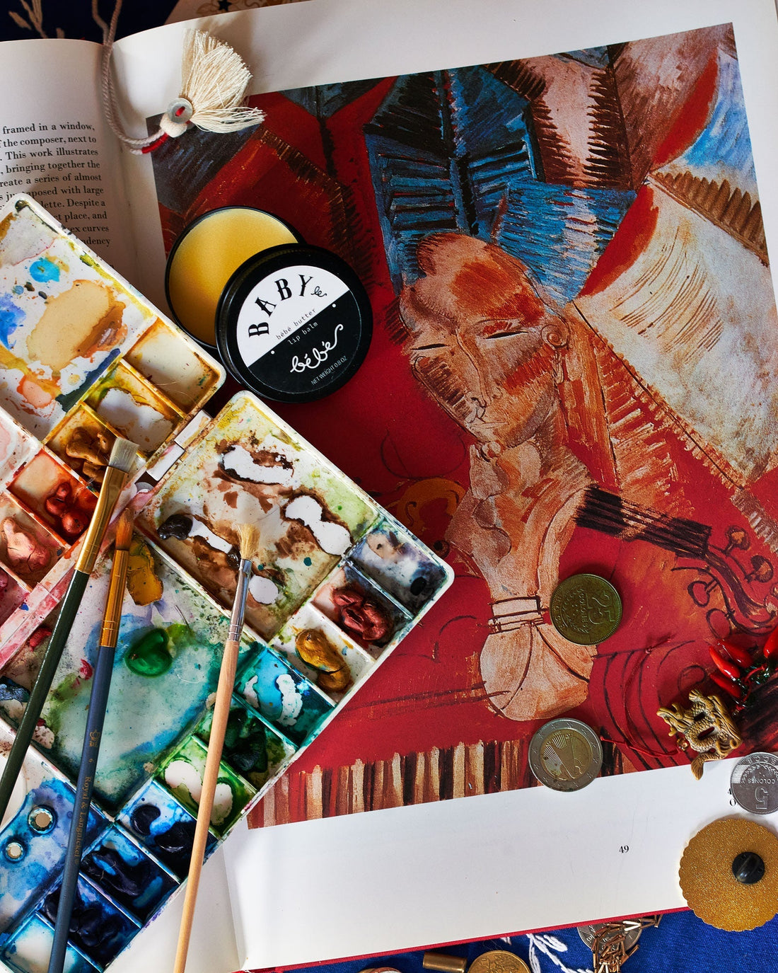 Image of painting supplies with a container of sinking balm in the center