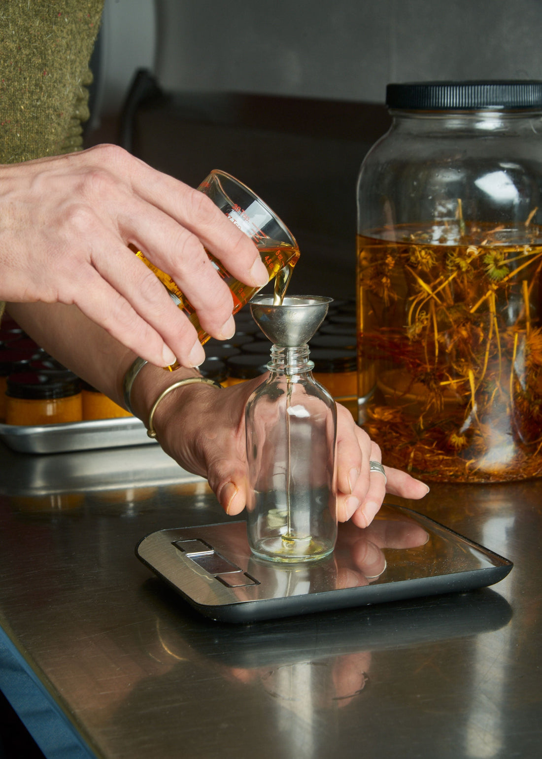 Person pouring oil into a vial to make a product