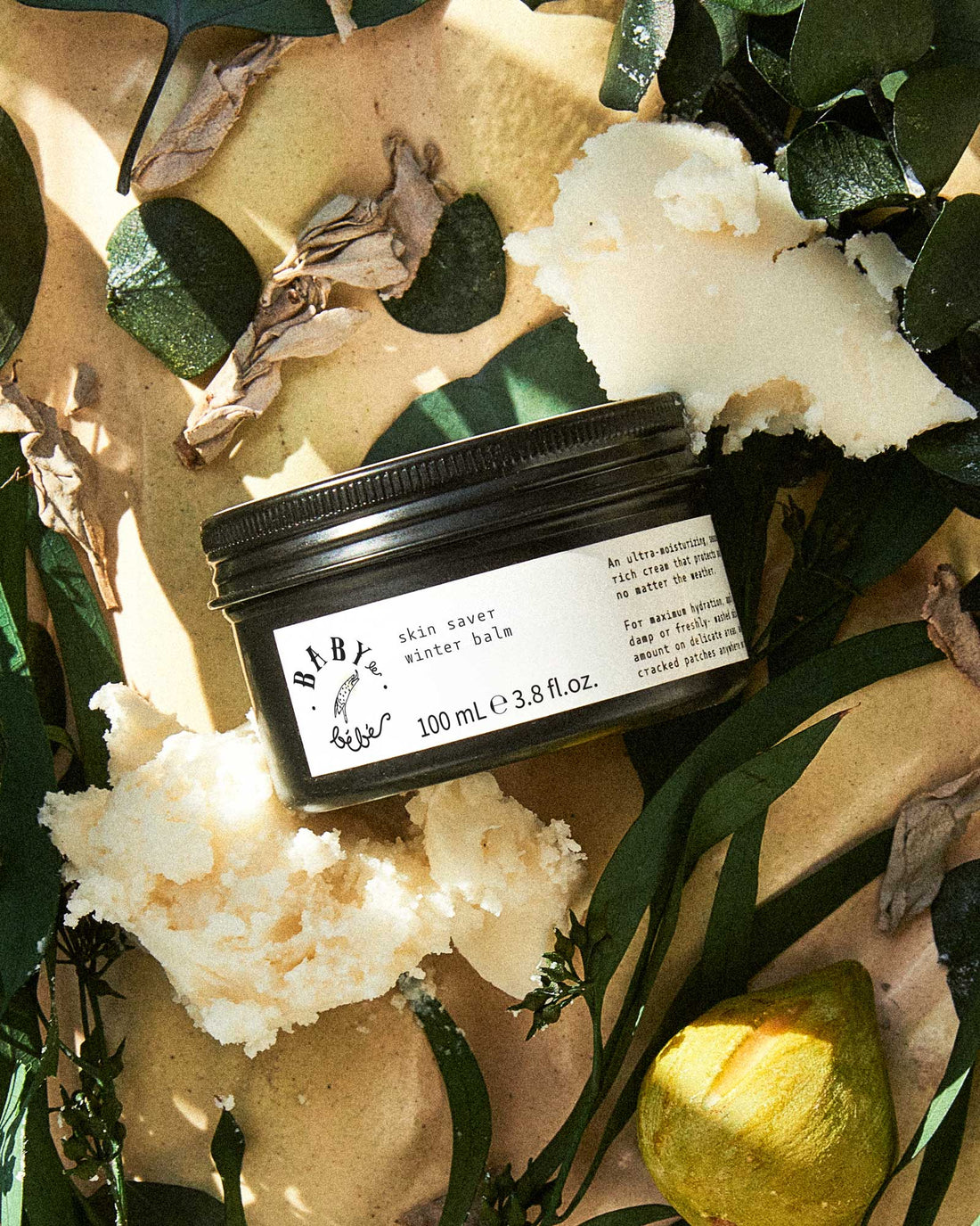 Photo of Lip balm in metal container surrounded by flowers 