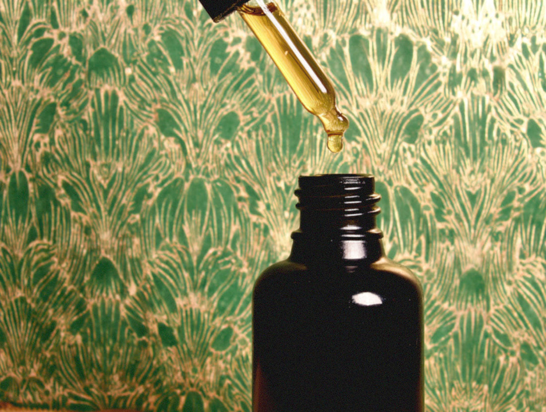 Close up view of dropper being removed from the vial of product.