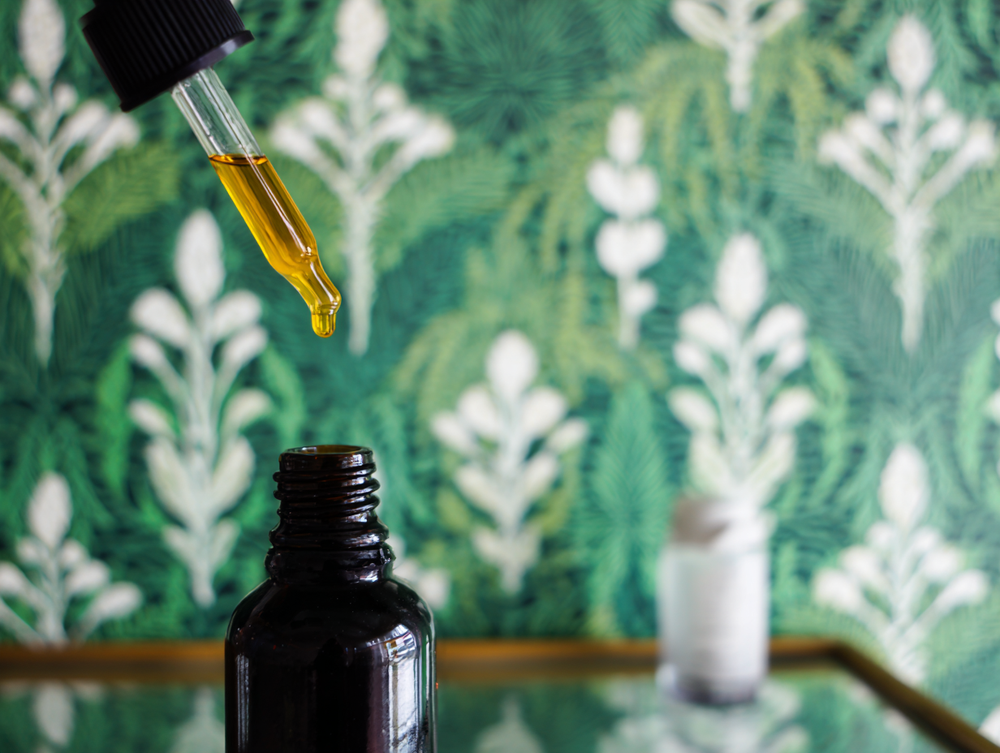 Image of a dropper being removed from a vial on a glass top table