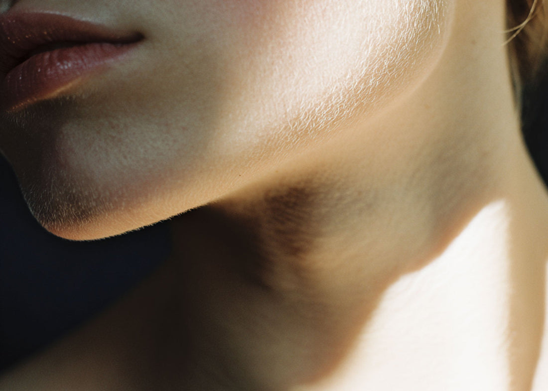 Close-up of a woman's jaw and neck in warm sunlight