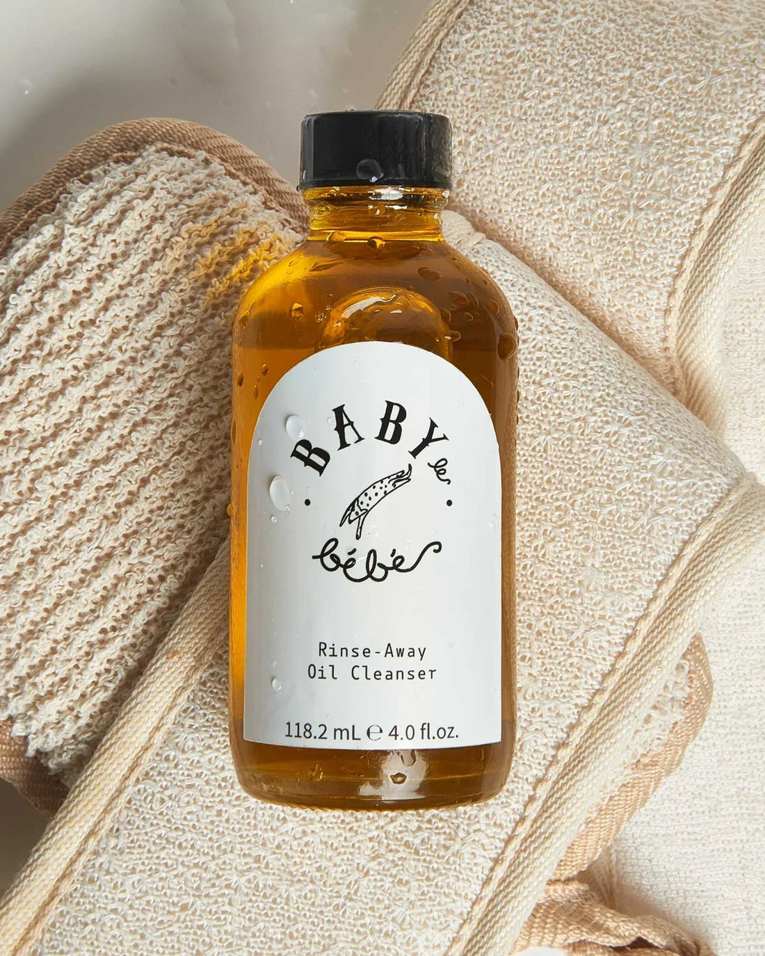 Bottle of rinse away oil cleanser with exfoliating cloth
