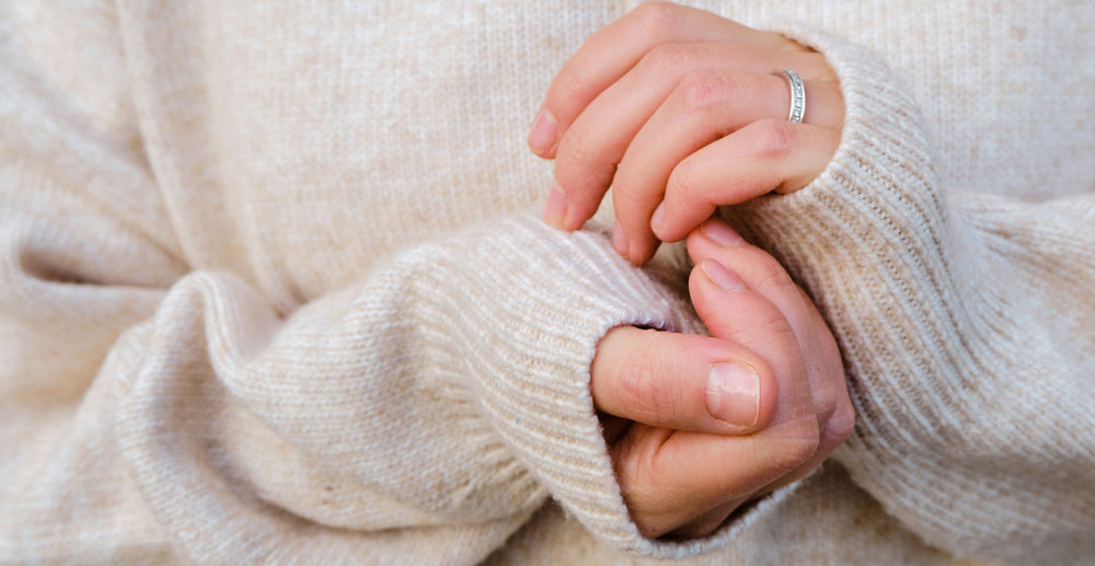Woman's hands poking out from sweater sleeve