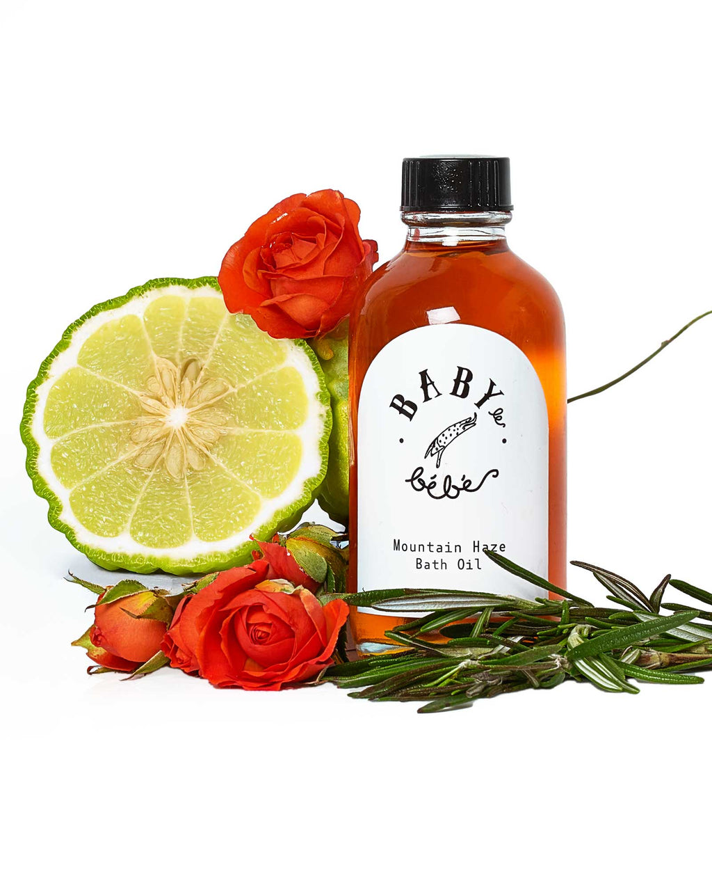 Bottle of Mountain Haze bath oil surrounded by bergamot fruit and roses 