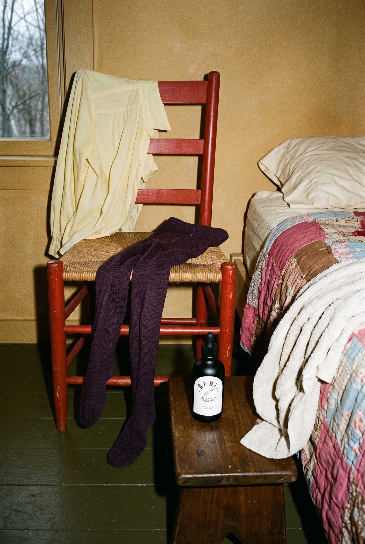 Baby le Bébé Smoothing Body Oil beside a chair with wool tights and a recently used bath towel.