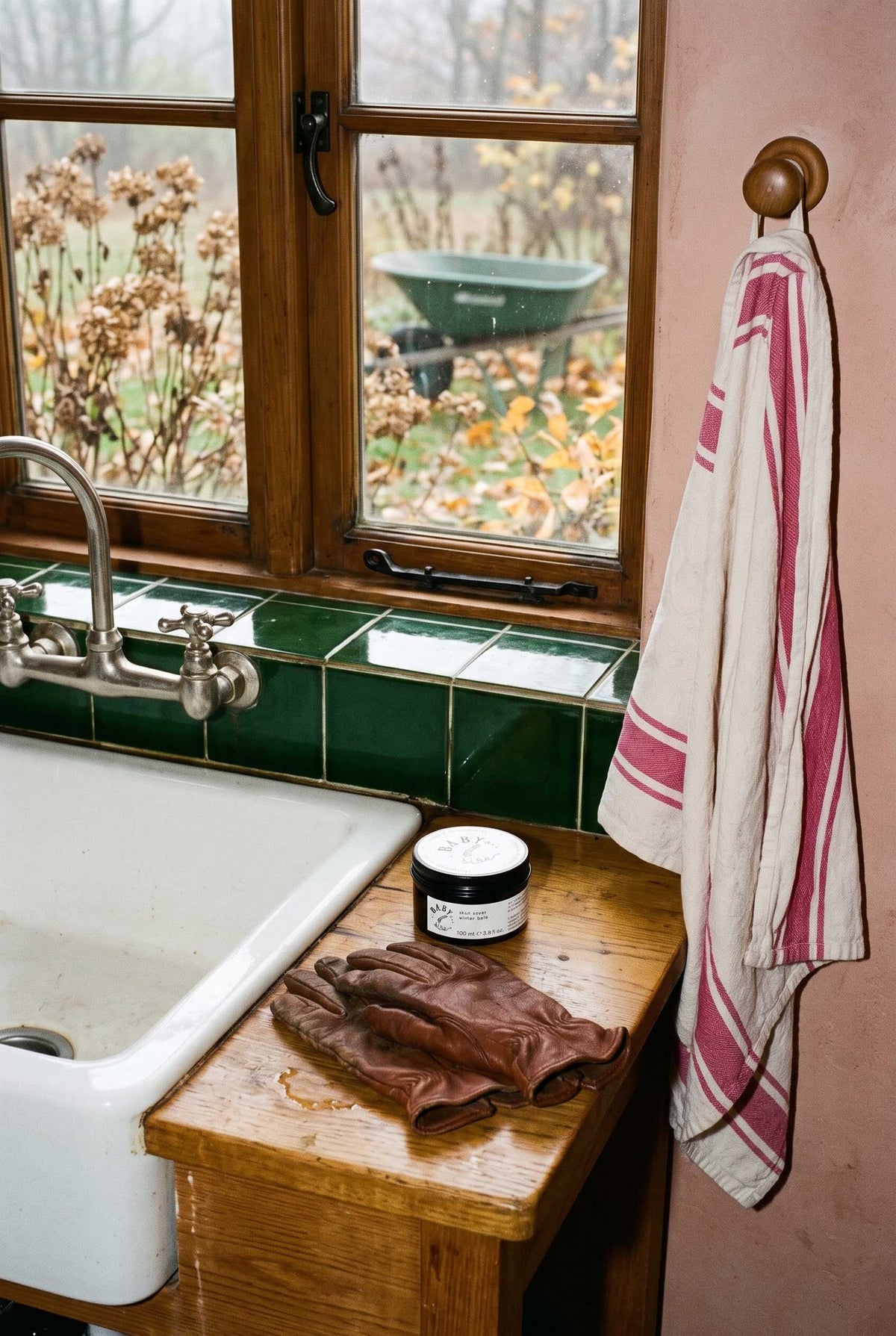 Removed gardening gloves and Baby le Bébé Skin Saver Winter Balm beside a freshly used basin.
